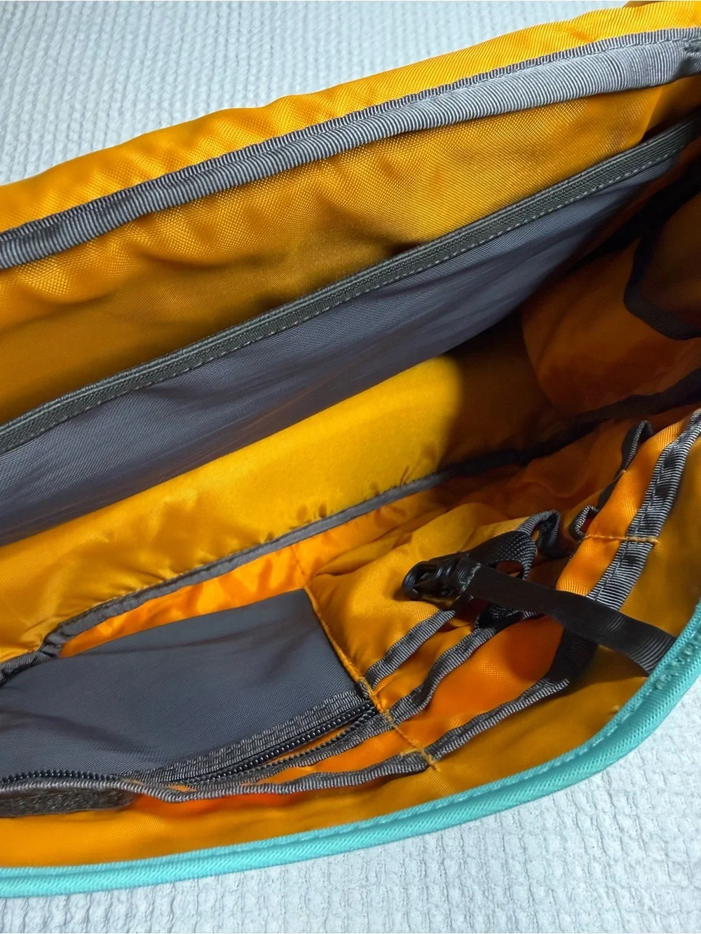 Patagonia Teal Messenger Bag with Yellow Zipper and Purple Strap